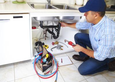 Plumber fixing kitchen sink