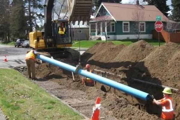 Workers laying pipe underground