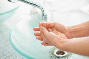 Person washing hands in sink
