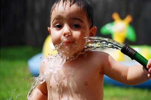 Boy Drinking Water from Hose