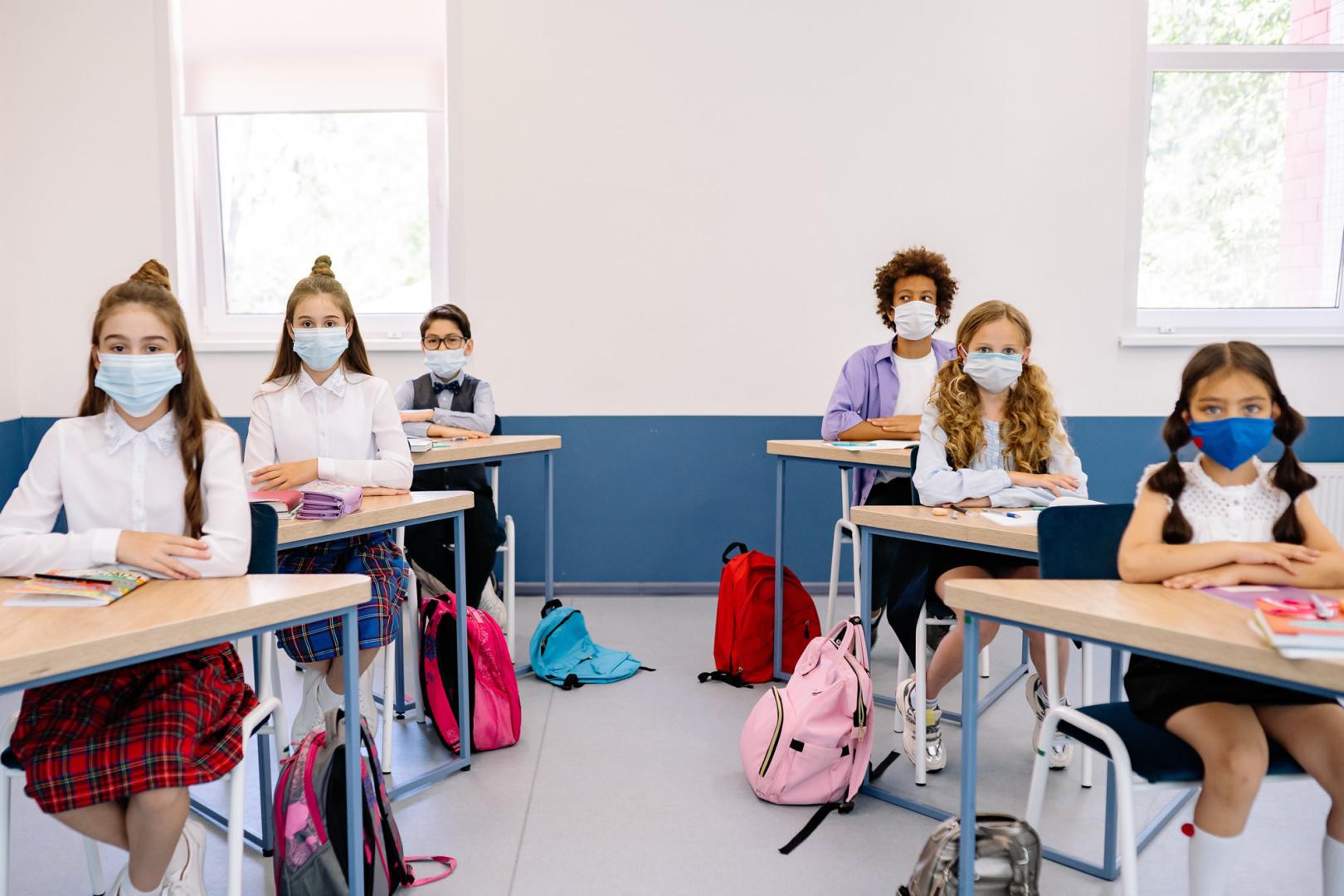 Children in classrooms wearing masks