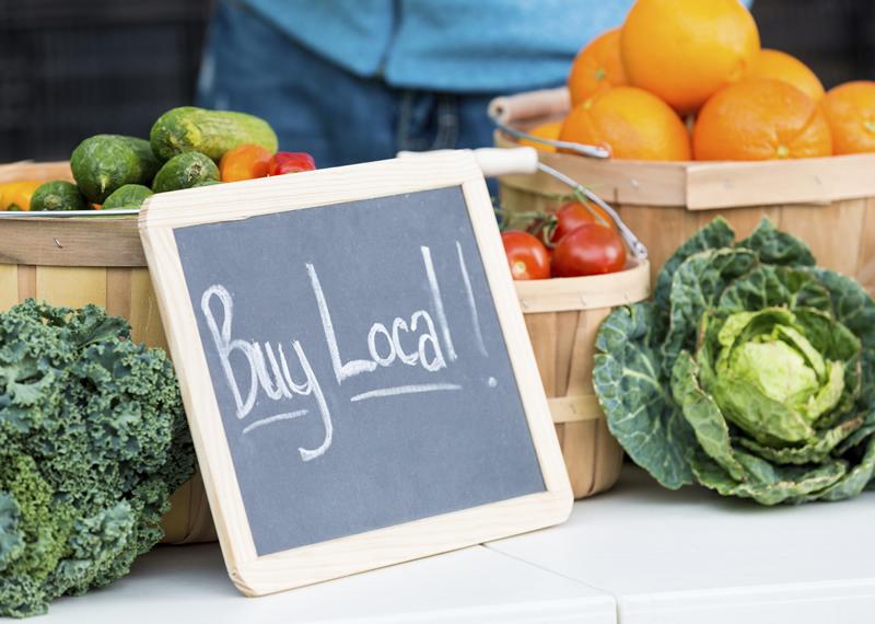 Buy Local sign in front of vegetables