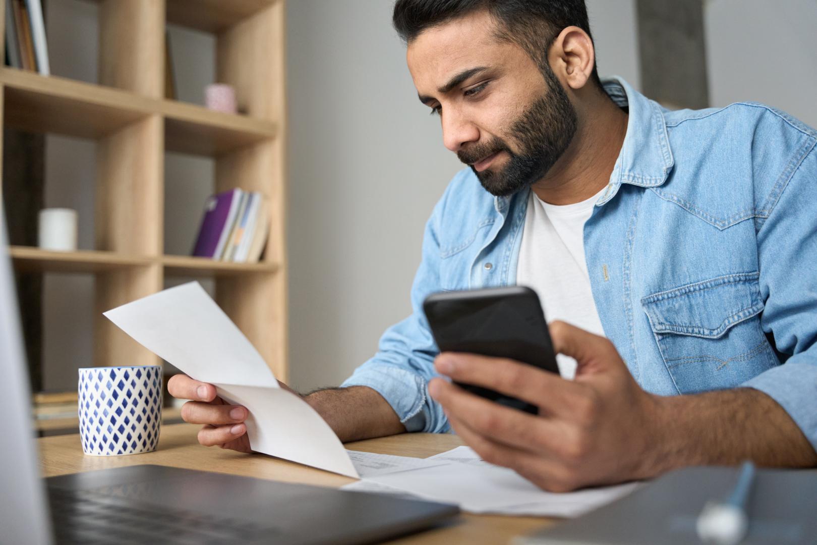 Man Paying Bills Holding Calculator 