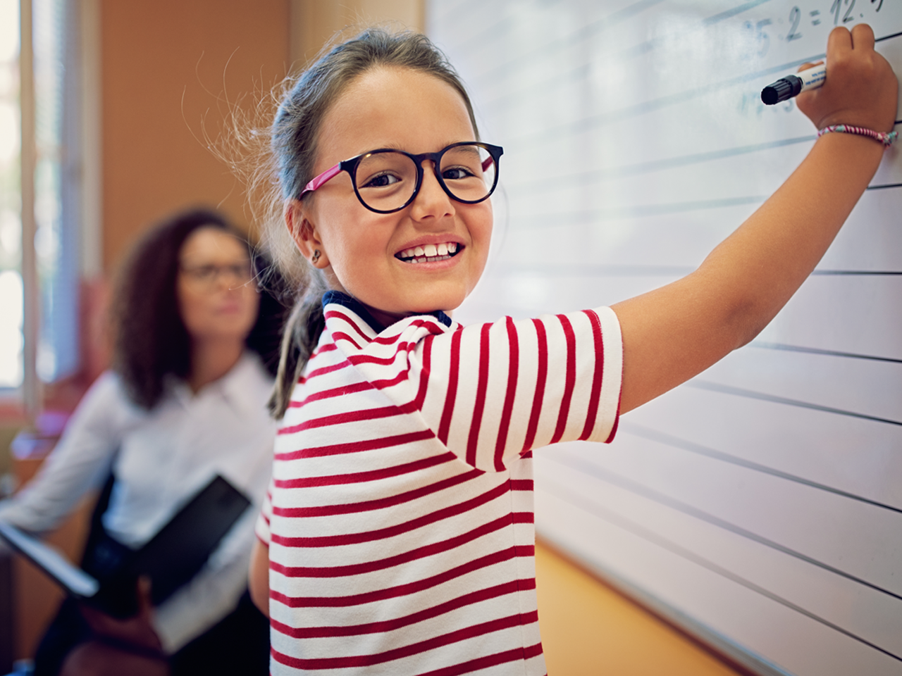 Young Student in Classroom with Teacher