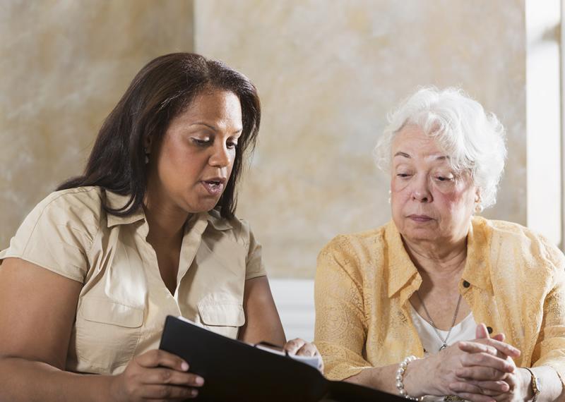 Individual reviewing legal document with older person