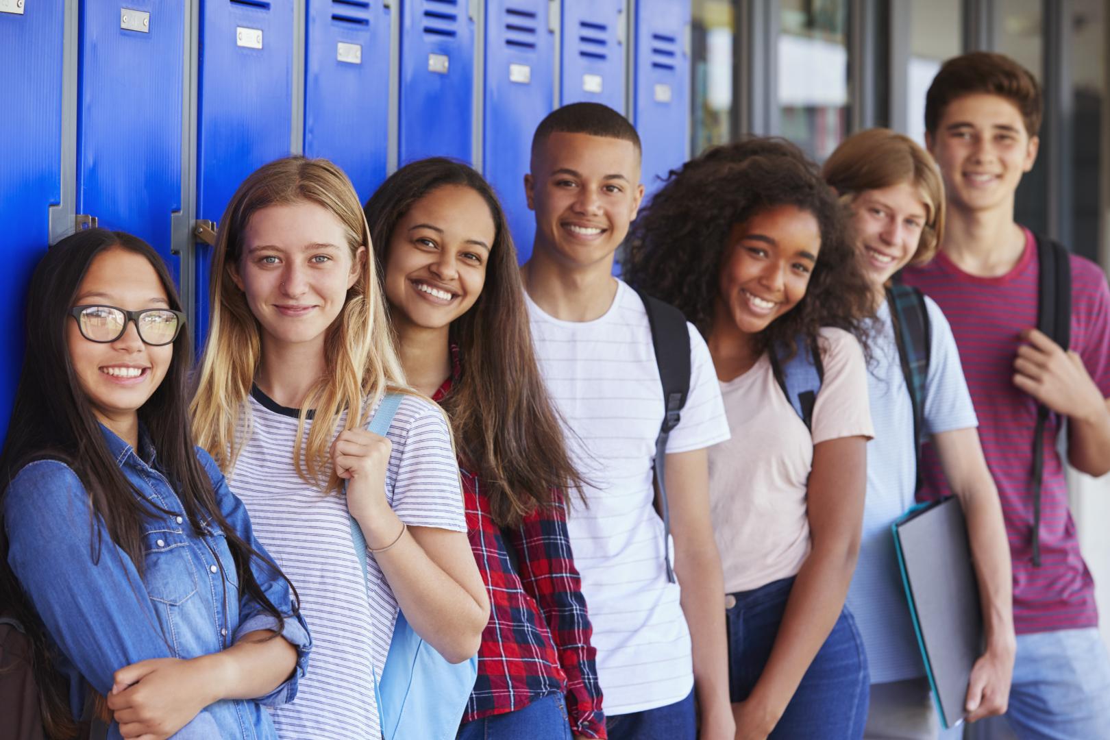 Youth standing against lockers