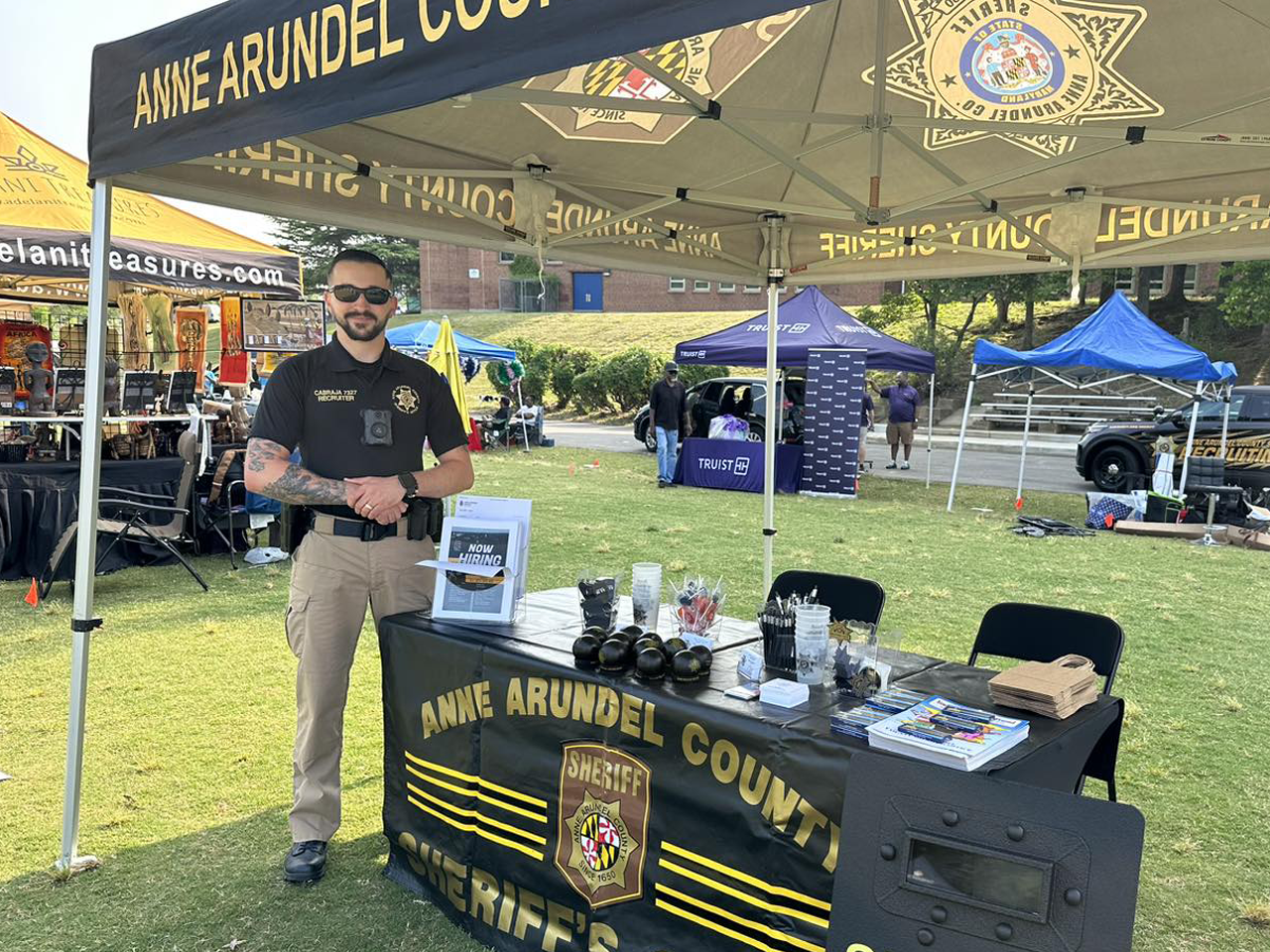 Sheriff next to pop-up tent at community event