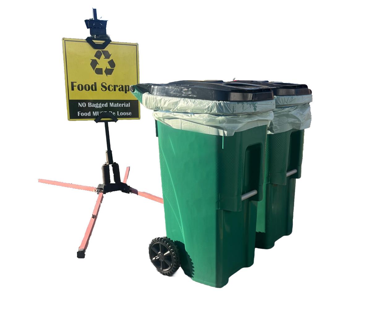 Two green carts used for collecting food scraps and a yellow food scraps sign.
