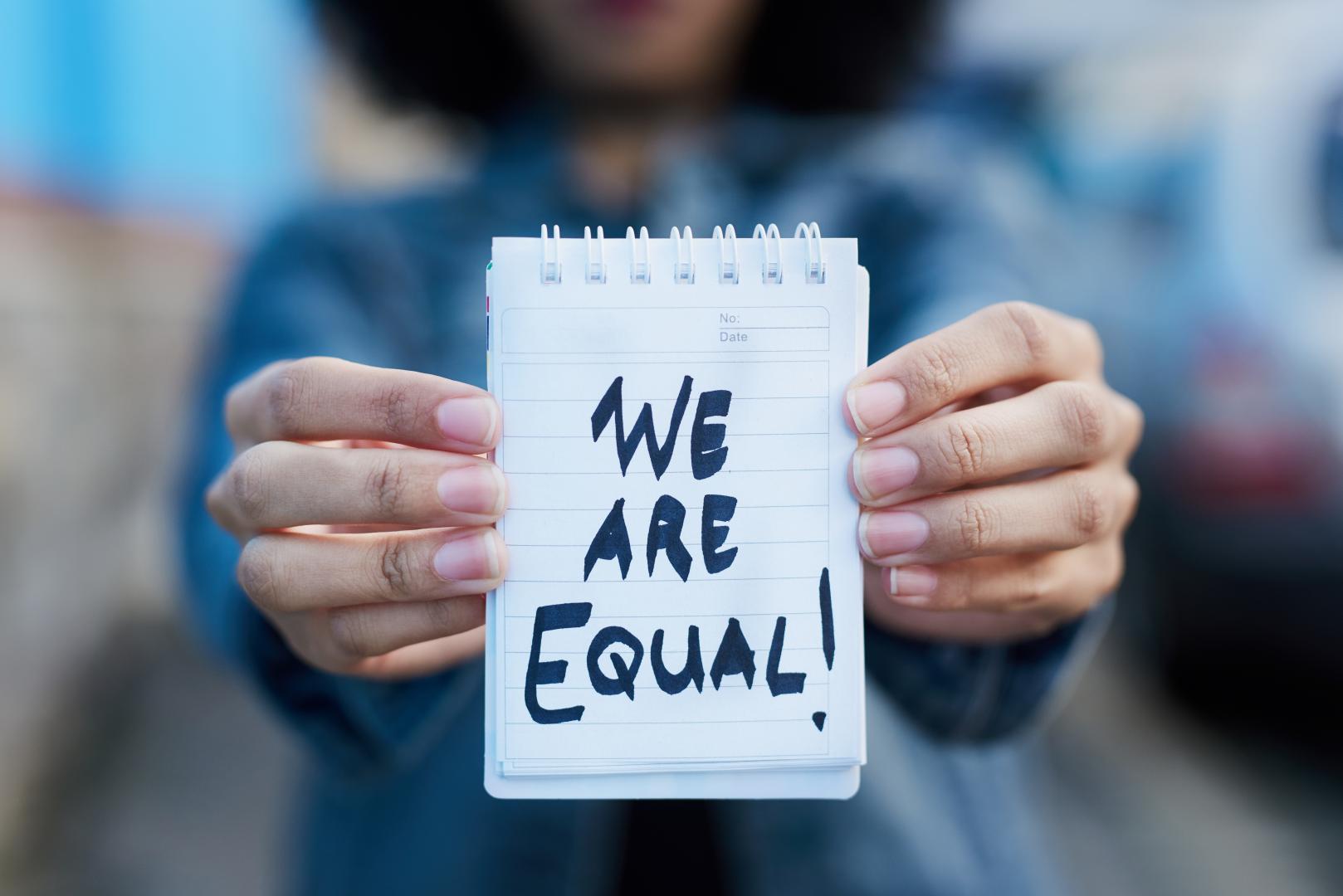 Person holding "we are equal" sign