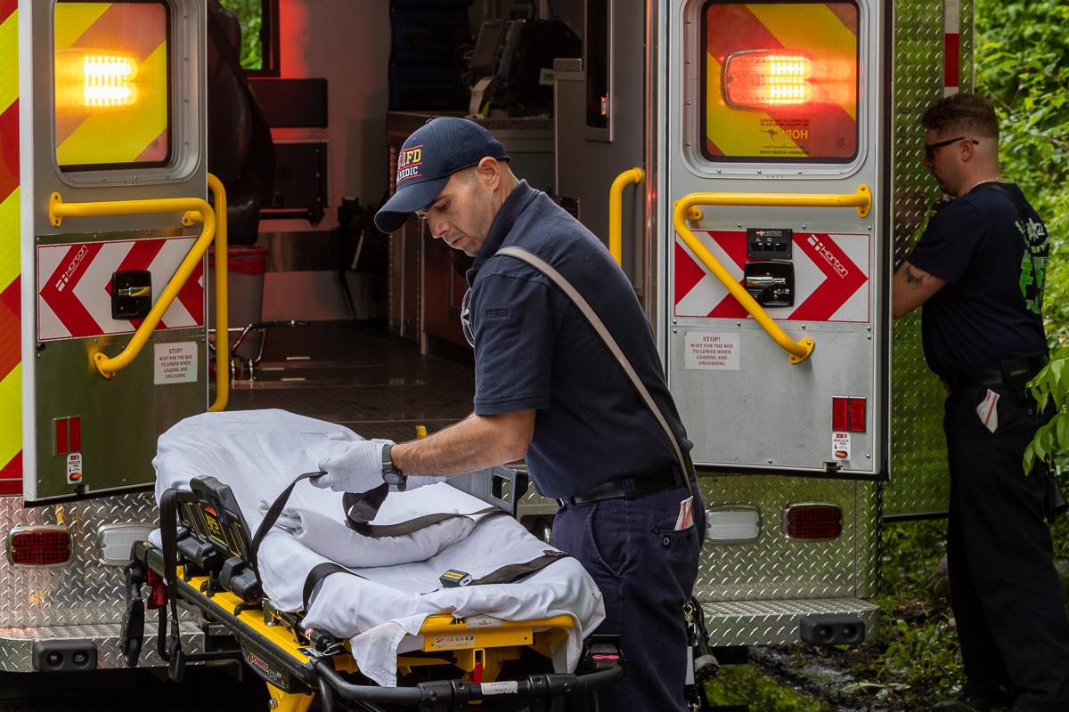 EMS putting gurney in back of an ambulance 