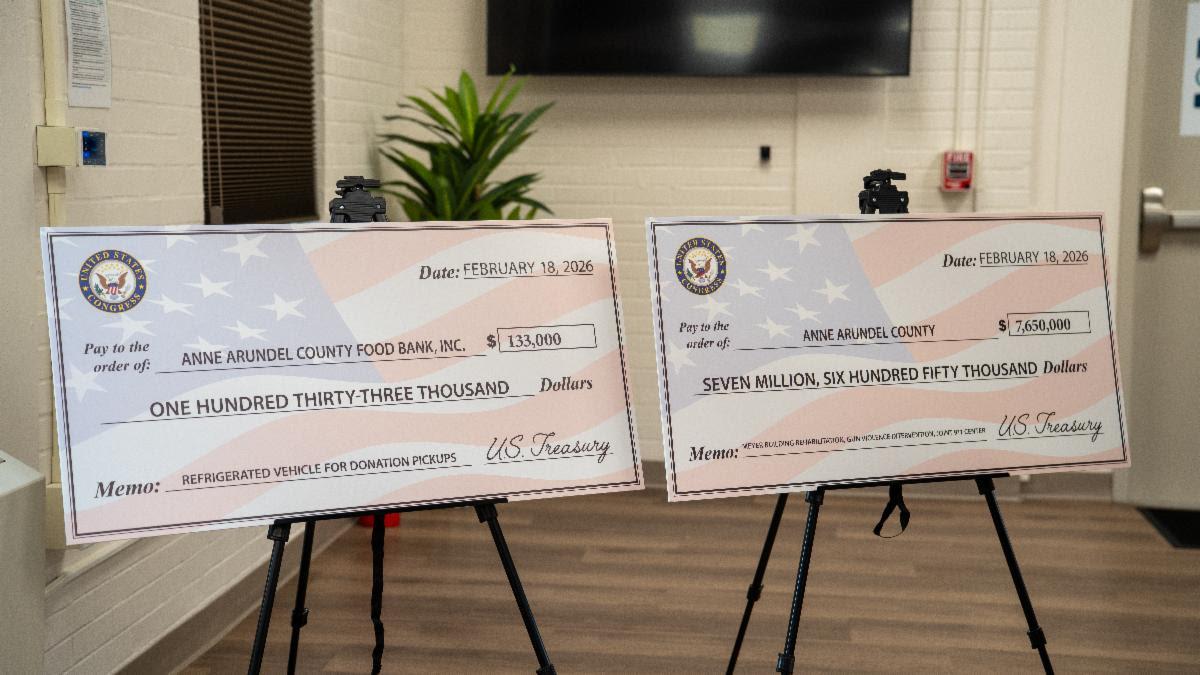 Two large oversized checks, one for the food bank and the other for Anne Arundel County