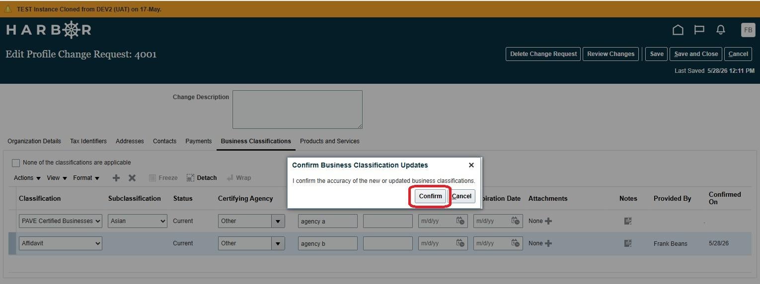 A "Confirm Business Classification Updates" dialog box centered over a dimmed HARBOR portal screen. The modal message reads, "I confirm the accuracy of the new or updated business classifications." A red rounded rectangle highlights the "Confirm" action button, situated next to "Cancel". The background shows the active "Business Classifications" tab layout with two updated data rows for "PAVE Certified Businesses" and "Affidavit". An orange banner at the top reads "TEST Instance Cloned from DEV2 (UAT)".