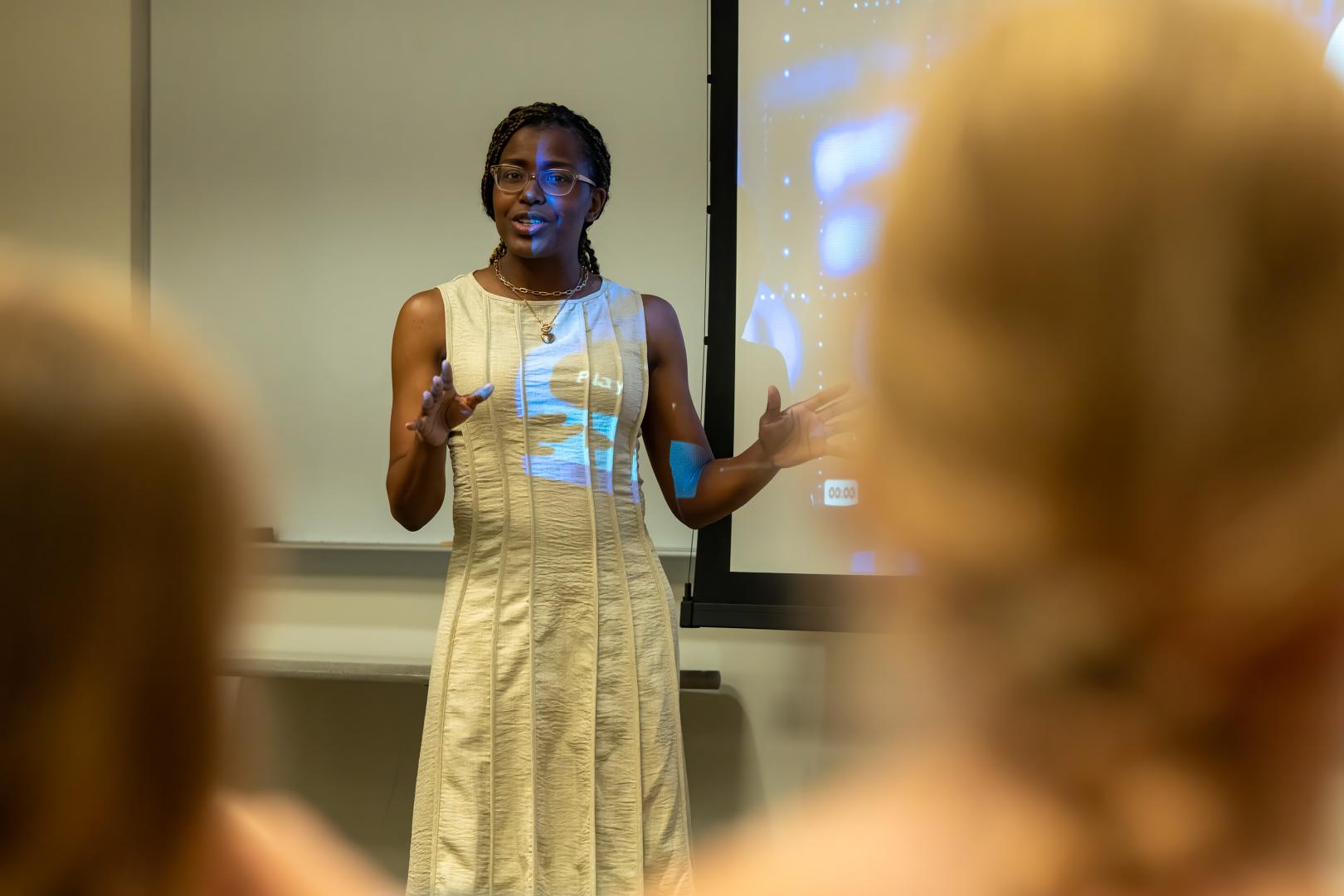 A speaker addressing a group of campers sitting in an audience at the HERoes on the HERizon leadership event