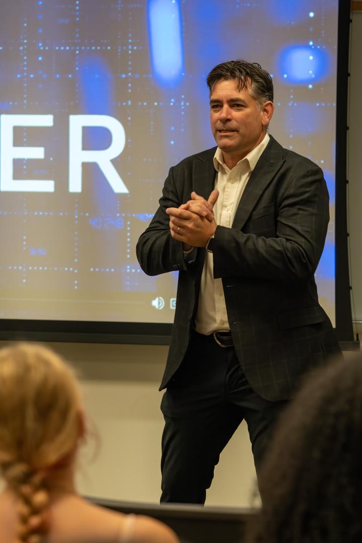 A speaker addressing a group of campers sitting in an audience at the HERoes on the HERizon leadership event