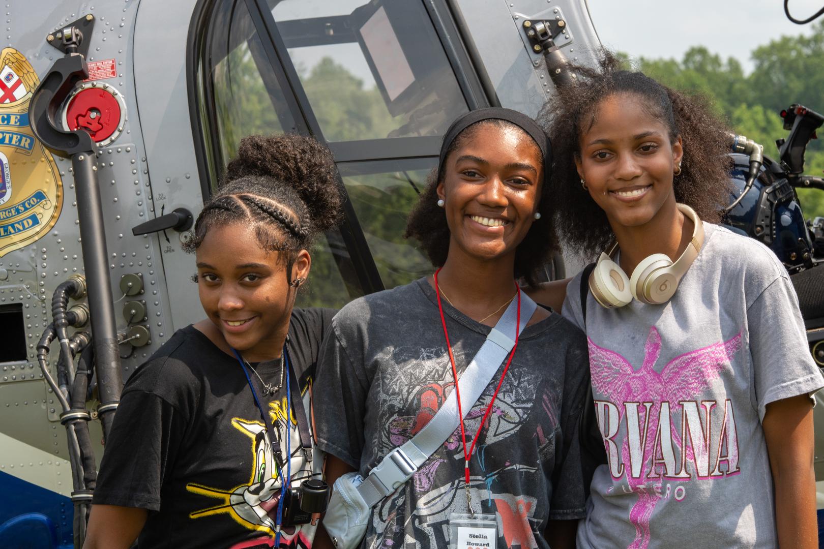 Young women participating in a team-building activity at the HERoes on the HERizon camp, engaged and smiling outdoors.