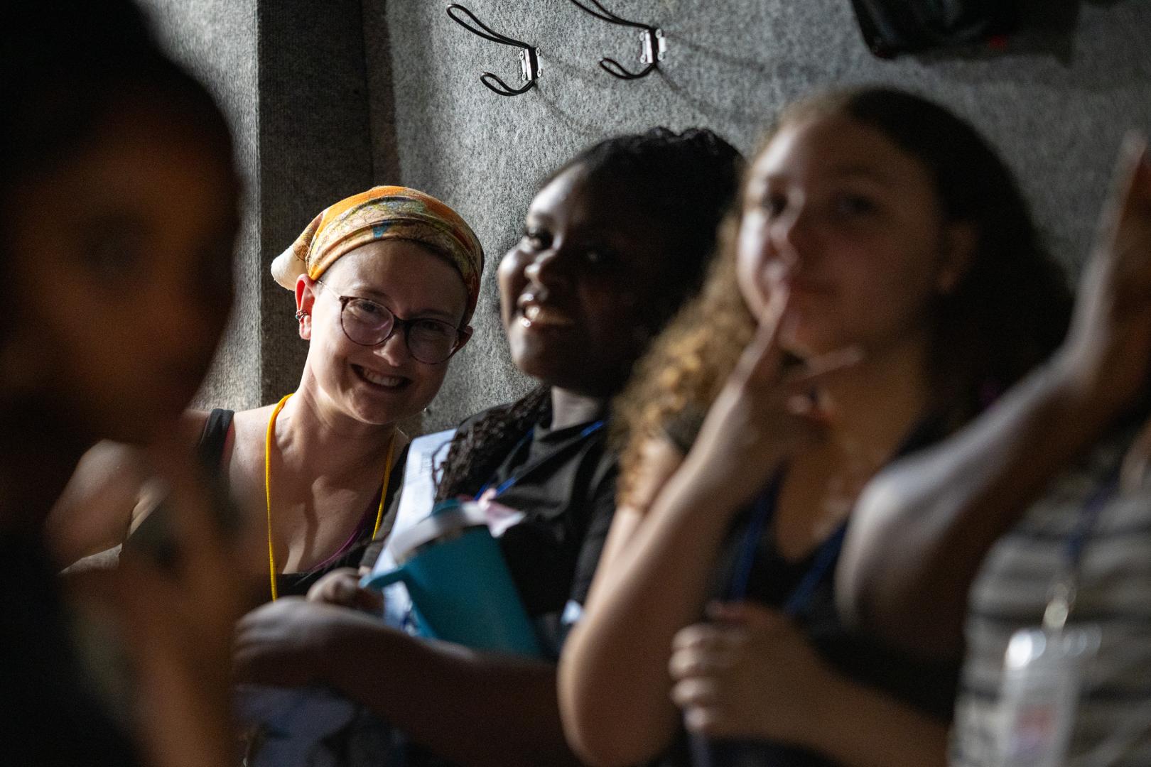 Group of young women participating in a team-building activity at the HERoes on the HERizon camp, engaged and smiling outdoors.