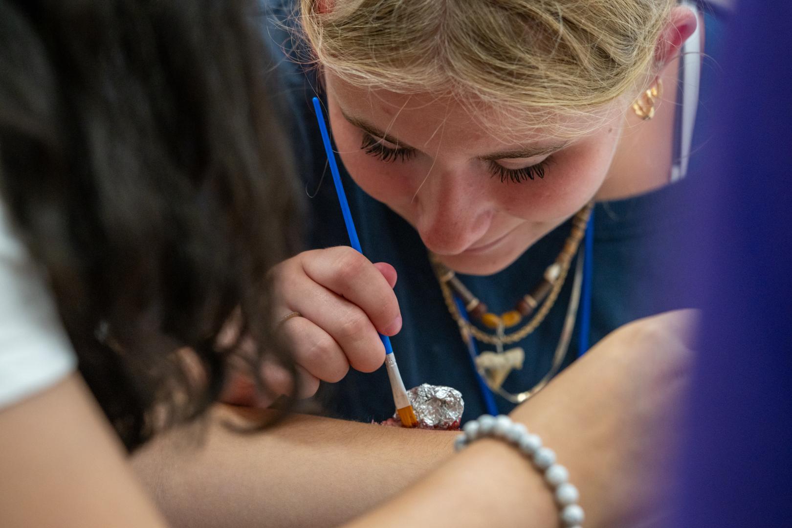 Camper participating in a team-building activity at the HERoes on the HERizon camp, engaged and smiling