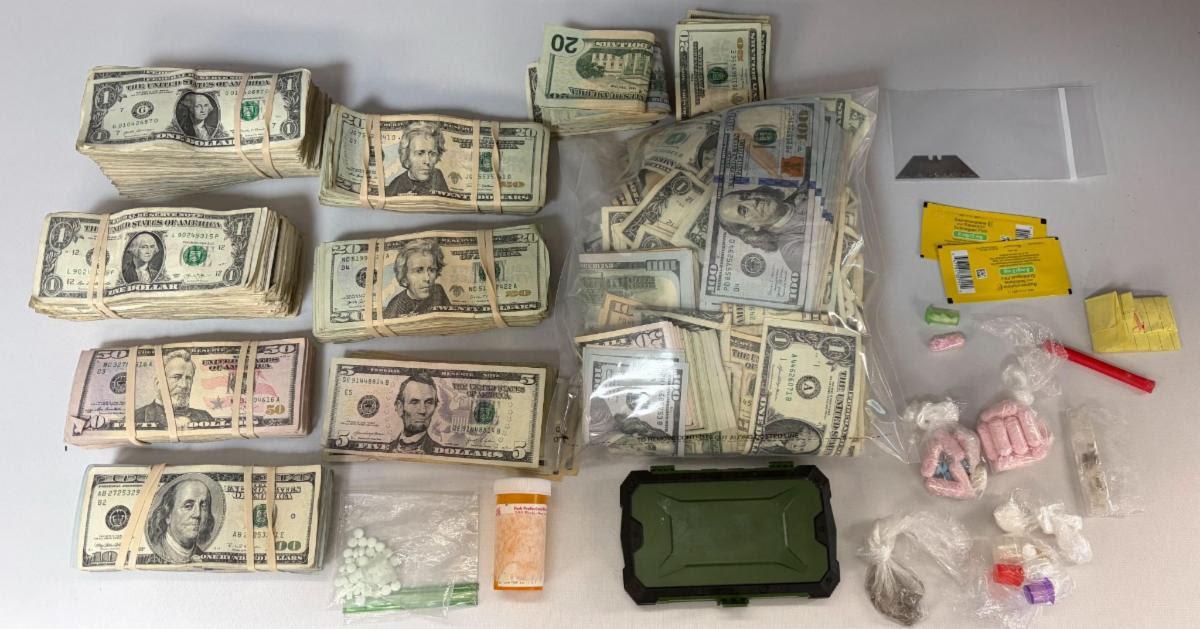 White table with 3.21 grams of suspected cocaine, 22.68 grams of suspected Fentanyl, 6.11 grams of suspected Crack Cocaine, 2.53 grams of suspected Suboxone, 49 suspected Oxycodone pills and $46,422 in currency.