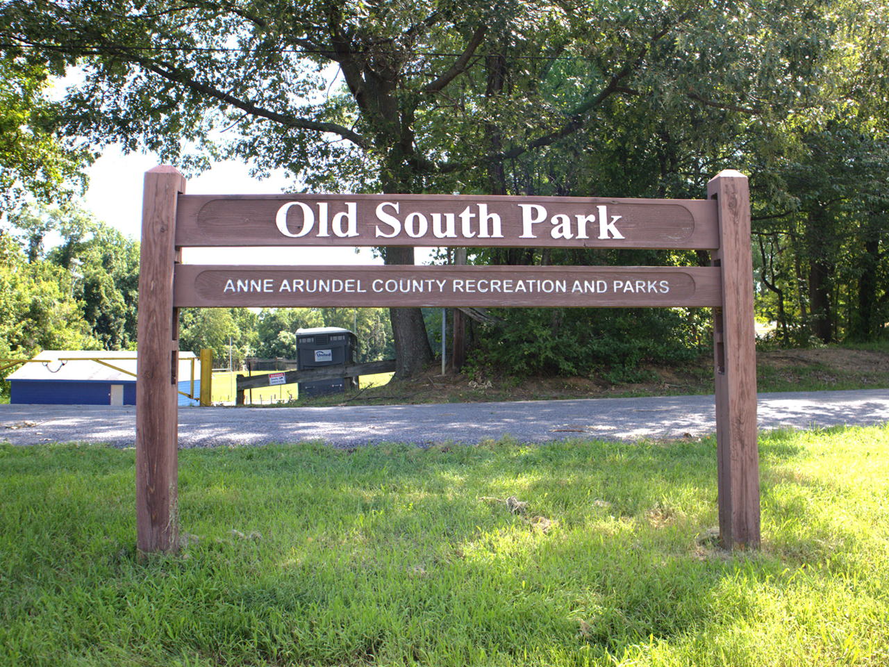 A wooden park entrance sign that reads "Old South Park" above "Anne Arundel County Recreation and Parks," set on a grassy lawn. 
